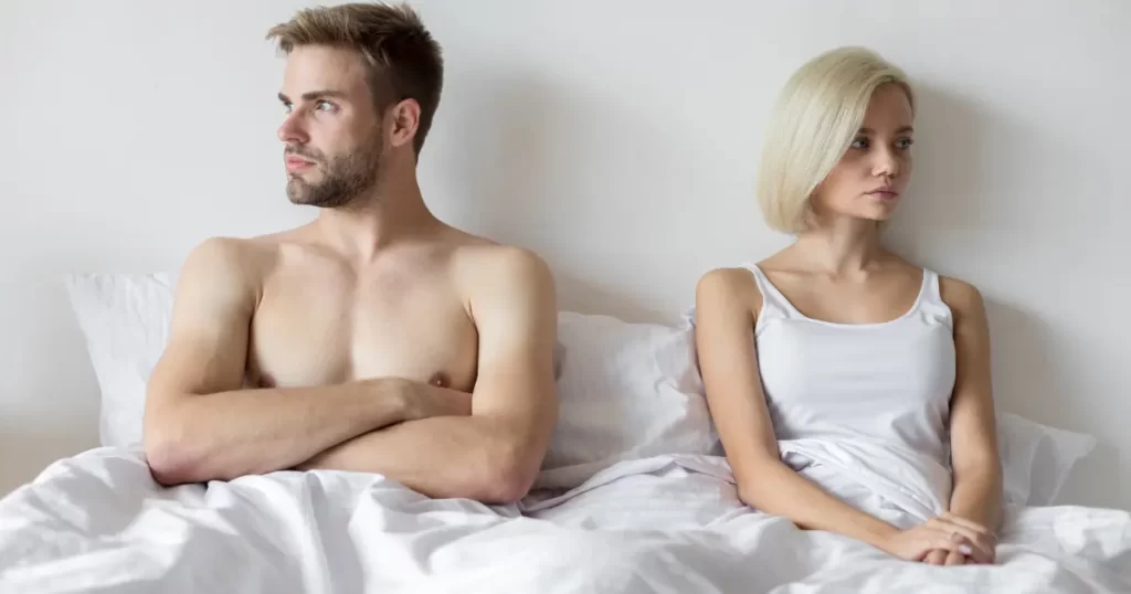 People pleasing couple sitting in bed not facing each other