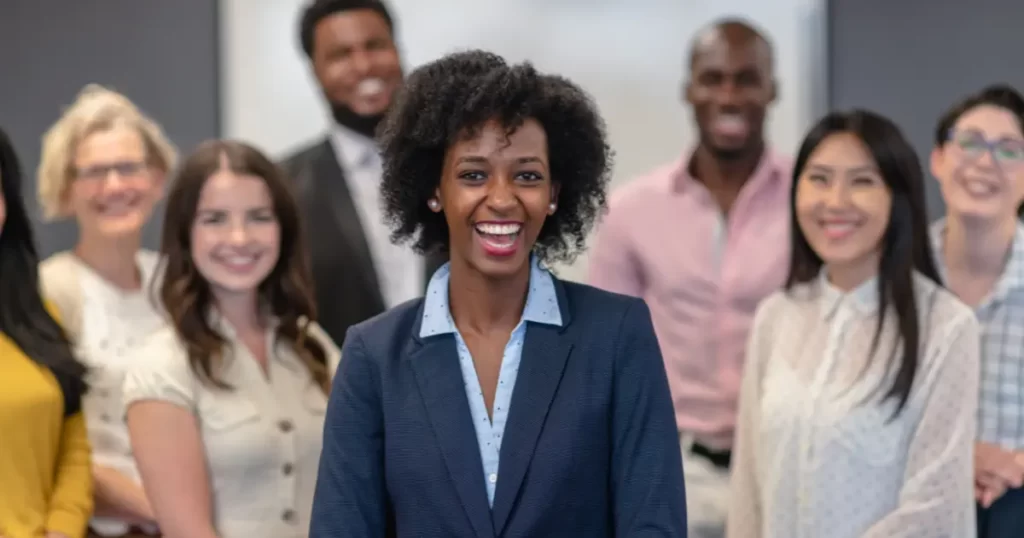 Professional woman in leadership role displaying masculine energy with people in the background